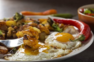 Küçük parça domuz eti, soğan ve sarımsaklı yumurta ve patates kızartması yemek. 