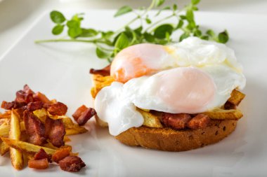 İki haşlanmış yumurta, patates kızartması ve pastırmalı tost.