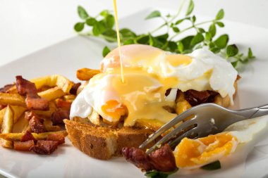 İki haşlanmış yumurta, patates kızartması ve pastırmalı tost.
