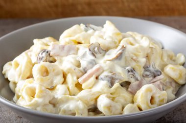 Mantarlı Ravioli ve krema ve peynir soslu jambon, İtalyan yemeği.