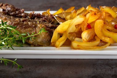 Kızarmış domuz pirzolası, dolma biber ve tabakta soğan Çin yemeği.