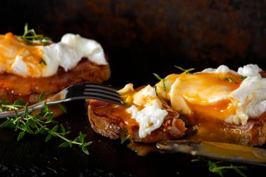 Dar tabaka üzerinde ev yapımı Benedict yumurtaları yemek. Yakın plan.