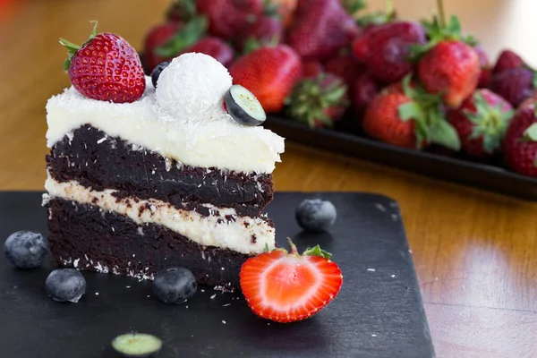 Beyaz ve siyah çikolatadan yapılmış lezzetli çikolatalı pasta, meyveler ve hindistan cevizi.