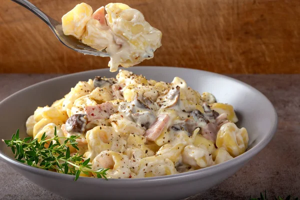 Mantarlı Ravioli ve krema ve peynir soslu jambon. İtalyan mutfağı.