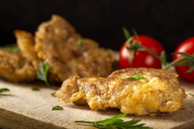 Domuz beyninden yapılmış şnitzel, un ve yumurtalar ahşap kesim tahtasının üzerinde - yakın görüş