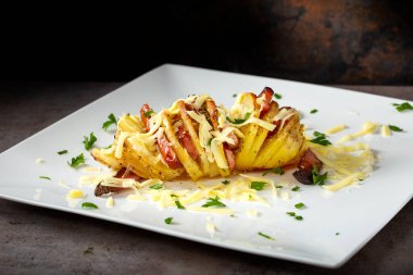 Domuz pastırması, sosis ve peynirle dolu akordiyon patatesleri.