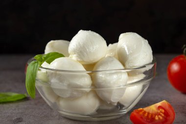 Mozzarella peynirli toplar, vişneli domates ve fesleğenli cam kase