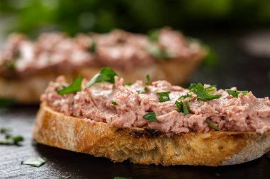 Koyu bir levhada doğranmış maydanozlu ciğer sosisli sandviç yakın plan detaylı olarak (seçici odaklanma))