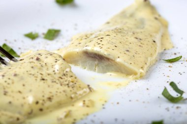 Terbiye edilmiş uskumru fileto, mayonez ve beyaz tabakta bitkiler.