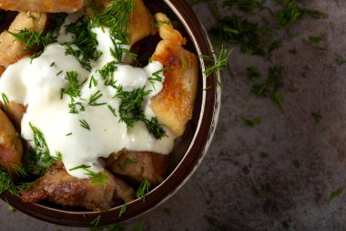 Kızarmış tavuk eti, krema sosu ve tavada doğranmış dereotu.