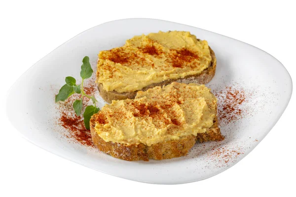 İki açık sandviç, humus ve tabakta kırmızı biber tozu. Beyaz arka planda, kırpma yolu ile izole edilmiş.