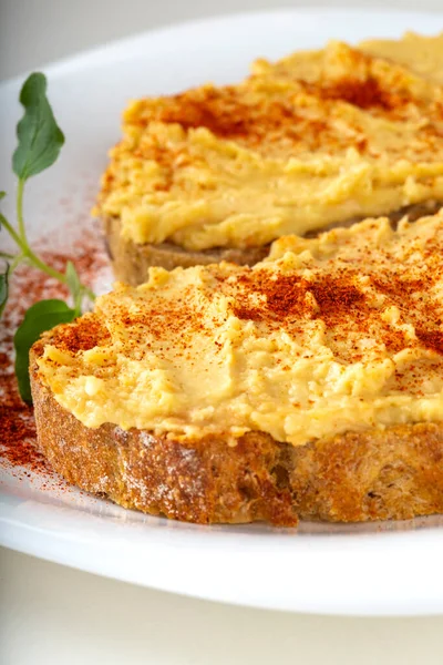 İki açık sandviç ve beyaz tabakta kırmızı biber tozu - dikey yakın görüş