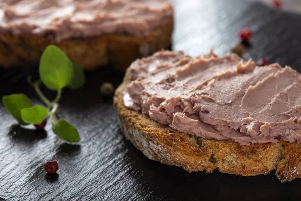 Açık sandviçler, domuz eti ve hindi ciğerinden yapılmış koyu bir levhada tatlı kızılcık reçeli. 