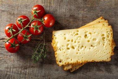 Tahtada kiraz domatesli üç dilim şeiben peyniri.