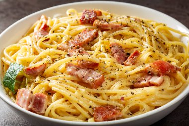 Pancetta 'lı spagetti carbonara, beyaz kasede yumurta ve peynir.