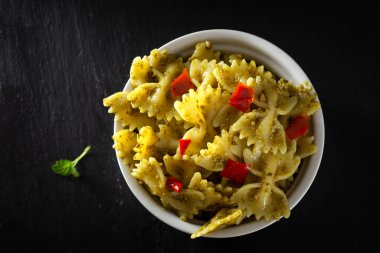 Pesto soslu Farfalle makarna ve kırmızı acı biber parçaları - üst manzara