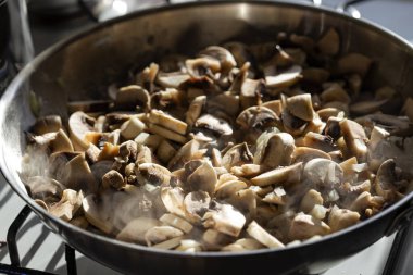 Tavada zeytinyağlı doğranmış soğan ve mantar kızartma.