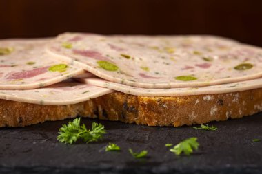 Zeytin ve biber gibi yeşil sebzelerden yapılmış salamlı sandviç.