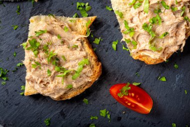 Ekmek domuz etli börek ve siyah bir tahta üzerinde bitkiler - üst görünüm