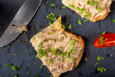 Ekmek domuz etli börek ve siyah bir tahta üzerinde bitkiler - üst görünüm