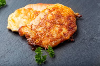 Siyah bir levhada iki parça domuz şnitzel.