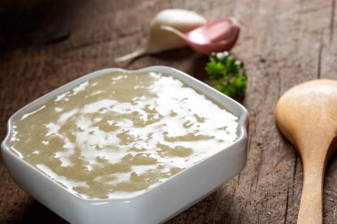 Küçük bir tahta kaşıkla taze sarımsak sosu.