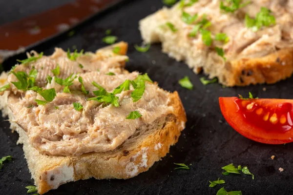 Domuz etli ekmek ve siyah bir sayfada otlar.