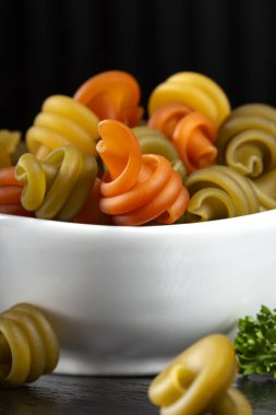 Beyaz kasede pişirilmemiş İtalyan makarnası. Yakın çekim.