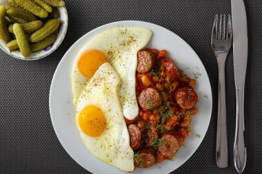Fasulye ve domuz sosisli sahanda yumurta.