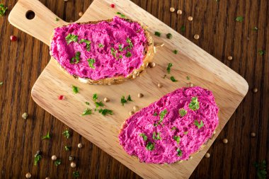 Ekmeğe yayılmış pancarla karıştırılmış keçi krem peyniri.