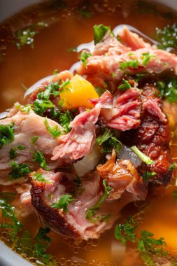 Tütsülenmiş domuz kaburgası, sebze ve ottan yapılmış et çorbası. Yakın görüş.