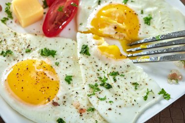 Kızarmış yumurta, vişneli domates ve peynir yemek.