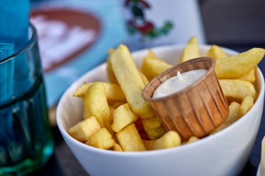 Patates kızartması ve mayonez sosuyla dolu bir kâse. Yakın çekim.