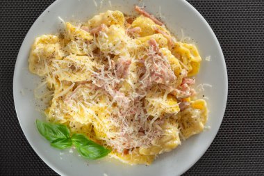 Jambonlu ve rendelenmiş parmesanlı Tortellini makarna.