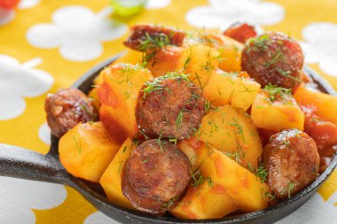 Domuz sosisli patates, tavada otlu güveç.