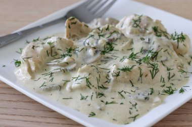 Geleneksel Romanya yemekleri: sarımsak aromalı kremalı dereotu sosuna sarılmış taze tavuk parçaları.