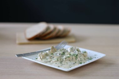 Geleneksel Romanya yemekleri: sarımsak aromalı kremalı dereotu sosuna sarılmış taze tavuk parçaları.