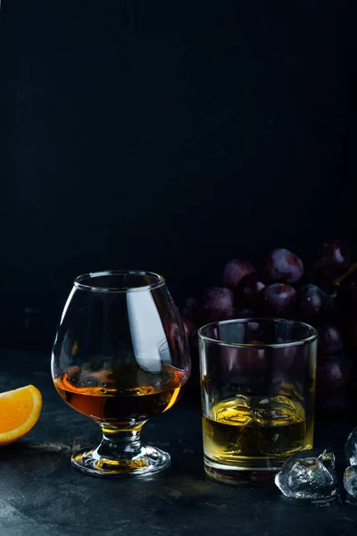 Whisky et cognac dans des verres sur un fond sombre. copyspace — Photo
