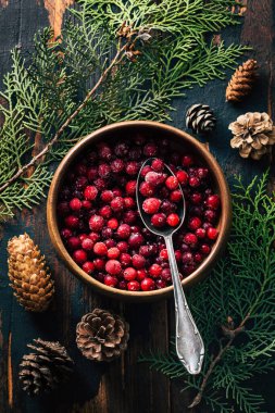 Ahşap arka planda bir tabakta kızılcık. Boşluğu kopyala