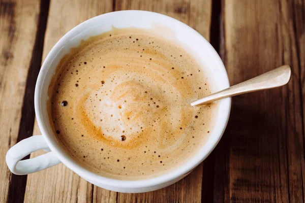 Köstlicher heißer Cappuccino auf Holztisch — Stockfoto