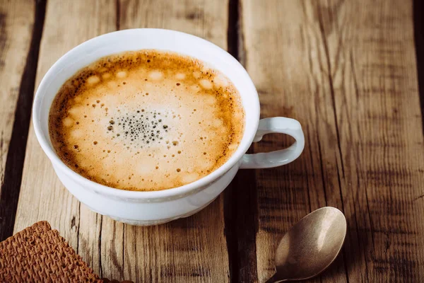 Köstlicher heißer Cappuccino auf Holztisch — Stockfoto