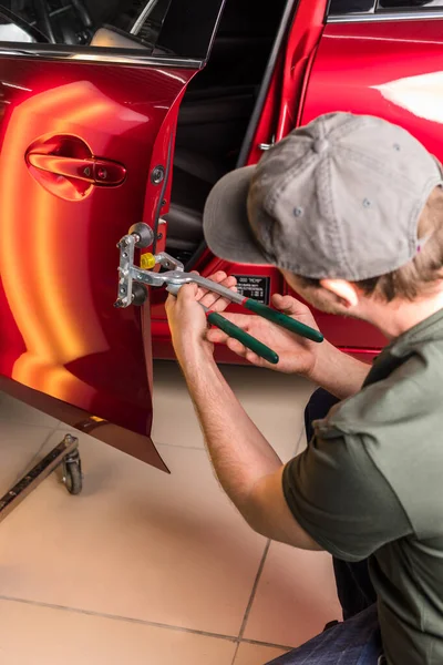 De technicus verwijdert deuken op de auto met behulp van de methode zonder te schilderen. PDR. Reparatie van carrosserie. — Stockfoto