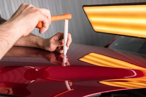 De technicus verwijdert deuken op de auto met behulp van de methode zonder te schilderen. PDR. Reparatie van carrosserie. — Stockfoto