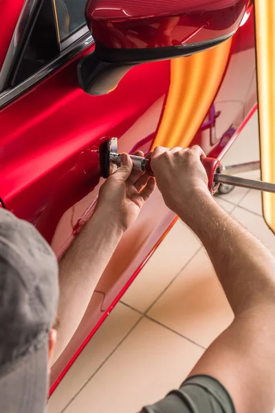 O técnico remove amassados no carro usando o método sem pintura. PDR. reparação do corpo do carro. — Fotografia de Stock