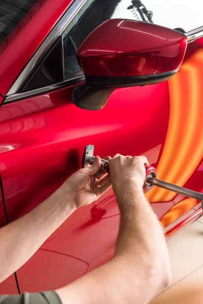 De technicus verwijdert deuken op de auto met behulp van de methode zonder te schilderen. PDR. Reparatie van carrosserie. — Stockfoto