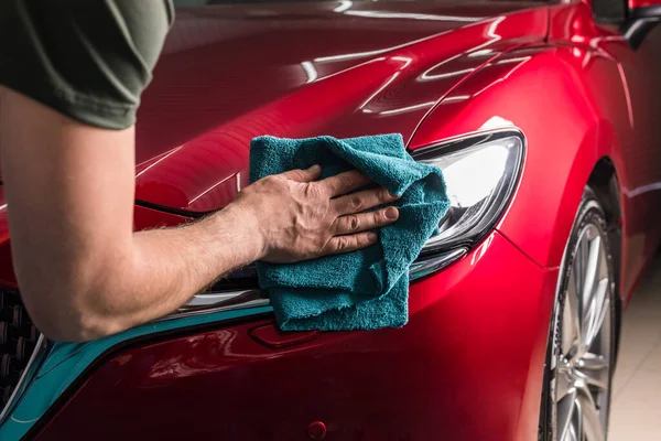 Polieren des Scheinwerfers eines roten Autos — Stockfoto