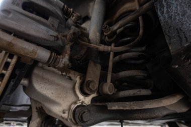 Otomobil tamir atölyesinde, bakım, makine mühendisliği veya otomotiv servis konsepti için ayrıntılı rotor, merkez ve süspansiyon sistemini gösteren araba fren diski ve kalibreli yakın çekim.  