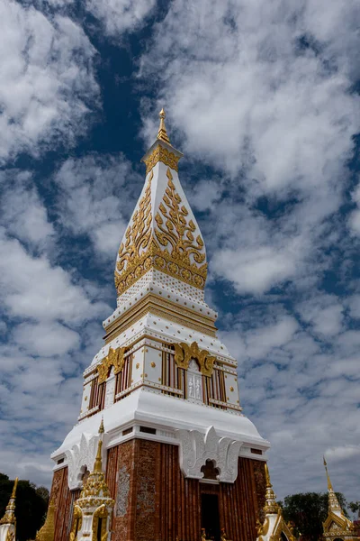 Phra That Phanom, altın oymaları ve beyaz mimarisi olan ikonik Budist ahmak, parlak mavi gökyüzüne karşı yükseliyor. Kutsal Tayland tapınağı simgesi, zengin kültür mirası ve ruhsal atmosfer
