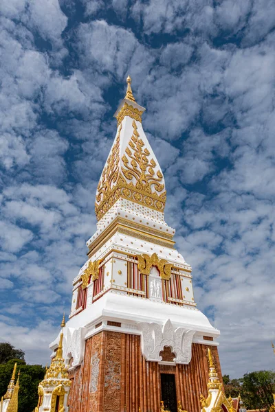 Phra That Phanom, altın oymaları ve beyaz mimarisi olan ikonik Budist ahmak, parlak mavi gökyüzüne karşı yükseliyor. Kutsal Tayland tapınağı simgesi, zengin kültür mirası ve ruhsal atmosfer