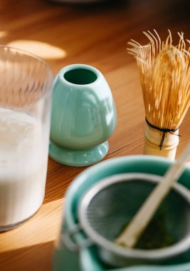 Kibrit kasesi, bambu çırpısı ve vegan sütü sıcak ışıkta masada.